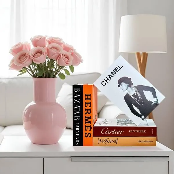 Affordable art coffee table books stacked on a stylish coffee table with ceramic decor and warm natural lighting