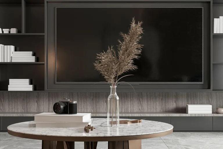 Minimalist coffee table with stacked neutral books, ceramic vase and warm natural light in a modern living room