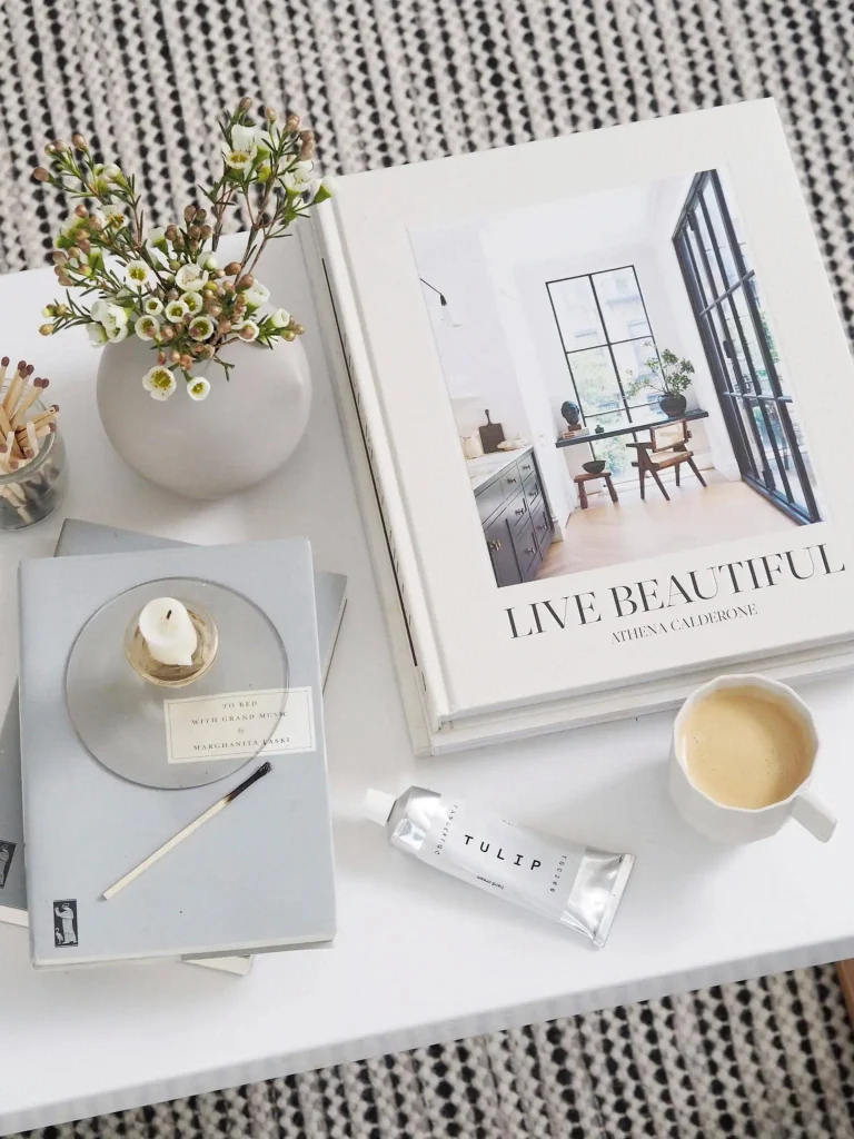 Elegant coffee table styled with art books, ceramic decor, candle, and creative interior elements for women who love art