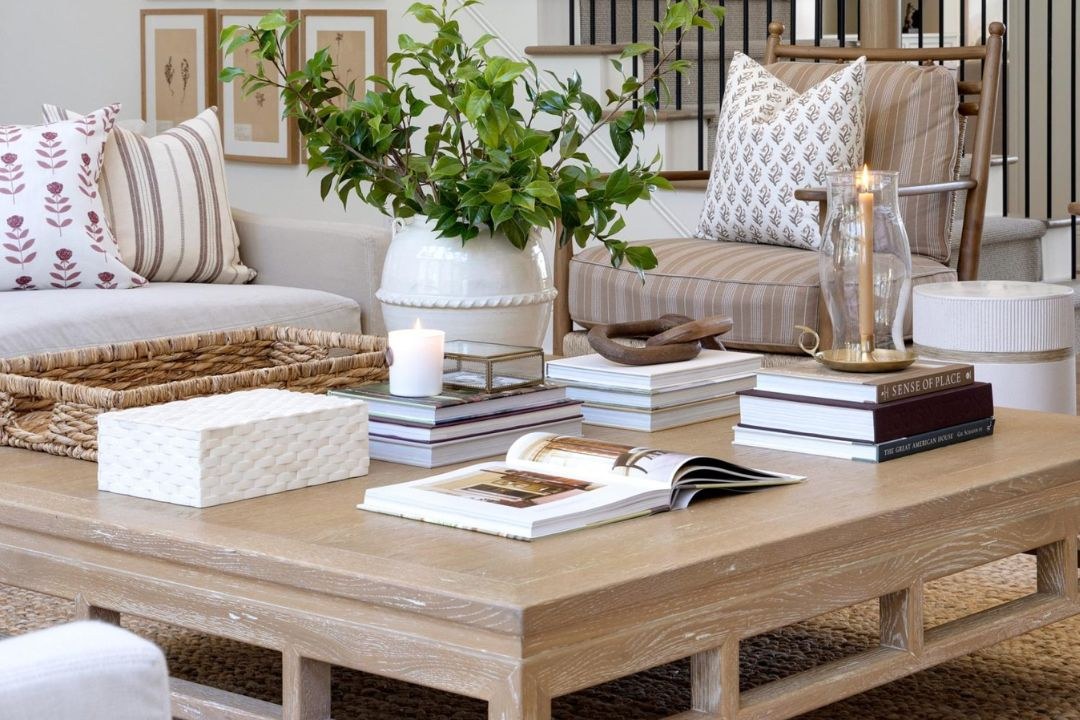 Stacked affordable coffee table books on a living room table with simple decor accents