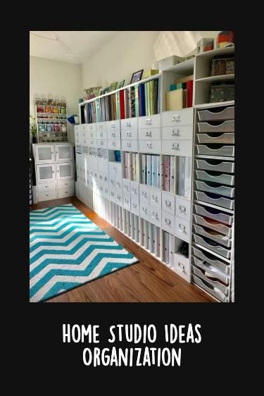 Person measuring a small home studio wall with shelves, desk, and storage bins before organizing