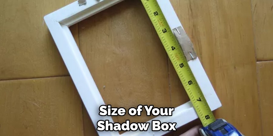 Hands using a tape measure to mark a wall for hanging a wooden shadow box