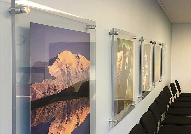 Framed art arranged on an interior wall away from direct sunlight, showing safe placement and balanced layout