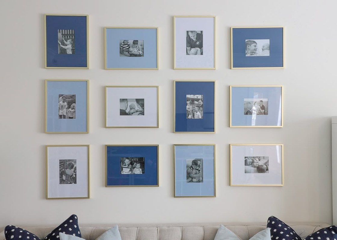 Gallery wall with framed artwork in beige, gray, and blue mats in a home living room